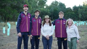 Group photo of AFL Brisbane Lions Players and QTFN CEO and GM in front of tree planting site